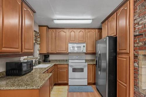 a kitchen with wooden cabinets and stainless steel appliances at Riverkern Retreat House in Kernville
