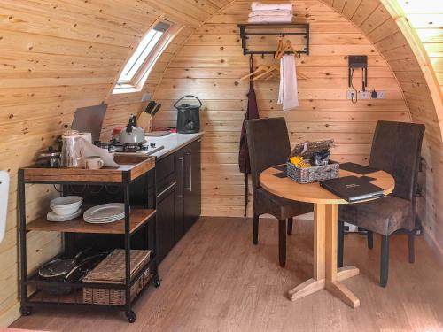 a kitchen with a table and chairs in a cabin at Hornbeam - Uk44262 in Waldron