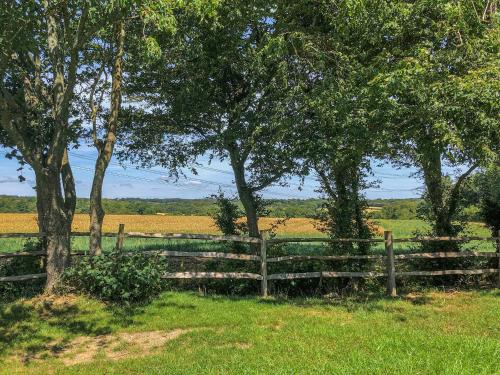 a wooden fence in a field with trees at Hornbeam - Uk44262 in Waldron