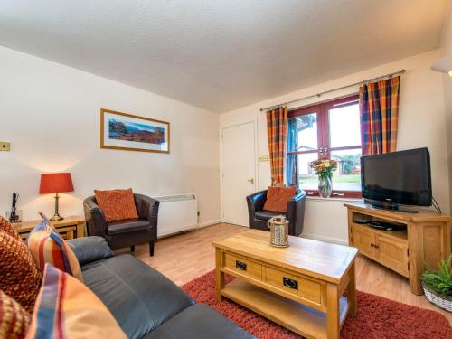 a living room with a couch and a tv at Munro View - Ukc5040 in Aviemore