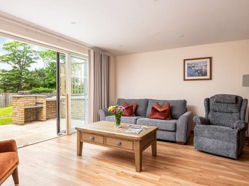 a living room with a couch and a table at Selkirk Lodge - Ukc5803 in Lundin Links