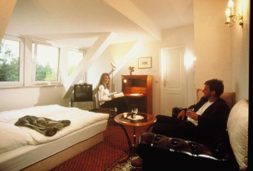 a man and a woman sitting in a hotel room at Apart Pension Babelsberg in Potsdam