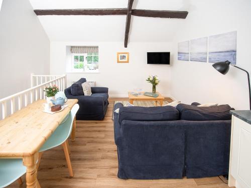 a living room with two blue couches and a table at Number Seven - Ukc4969 in Tawstock