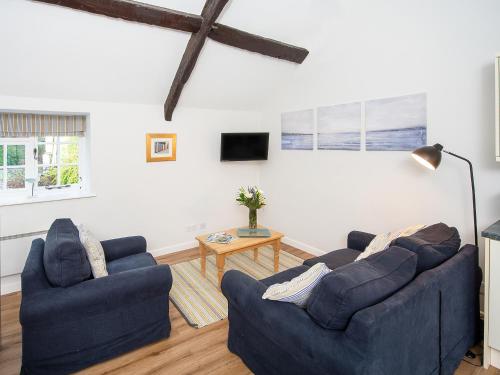 a living room with two blue couches and a table at Number Seven - Ukc4969 in Tawstock