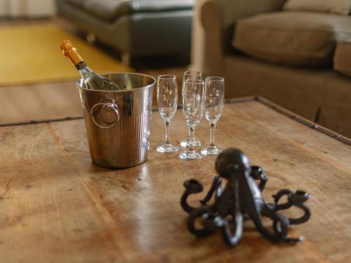 a bucket with a bottle of champagne and wine glasses on a table at Number One - Ukc4963 in Tawstock