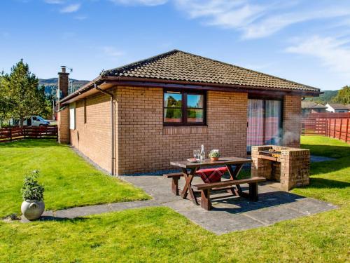 a picnic table in a backyard with a house at The Stag-Ukc5066 in Aviemore