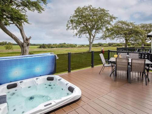 a hot tub on a deck with a table and chairs at Rivendale in St. Andrews