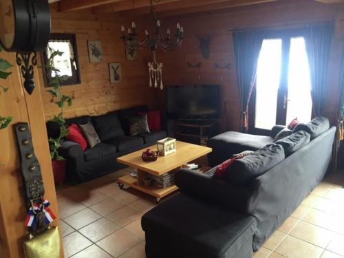 a living room with a couch and a table at Magnificent chalet on the mountain slopes in Les Gets