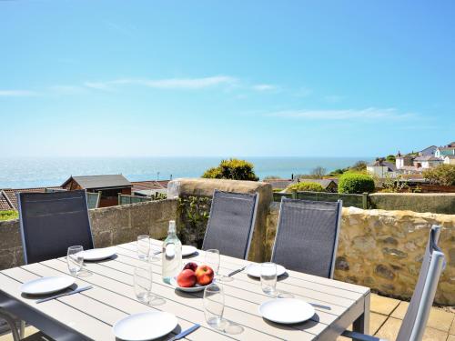 a white table with a bowl of fruit on it at Pebble Cottage in Ventnor