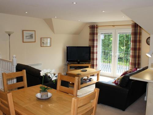 a living room with a table and a tv at Pine View in Invergarry
