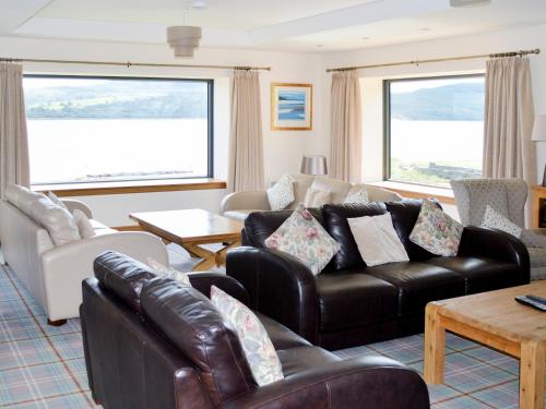 a living room with a leather couch and chairs at Dunmore Villa-Uk36498 in Tarbert