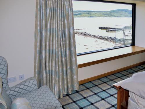 a bedroom with a window with a view of a marina at Dunmore Villa-Uk36498 in Tarbert