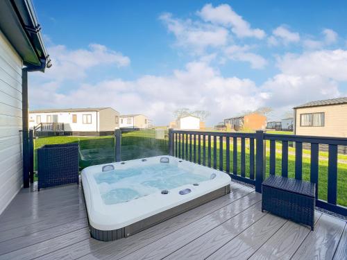 a hot tub on the deck of a house at Rivendale 52 in St. Andrews