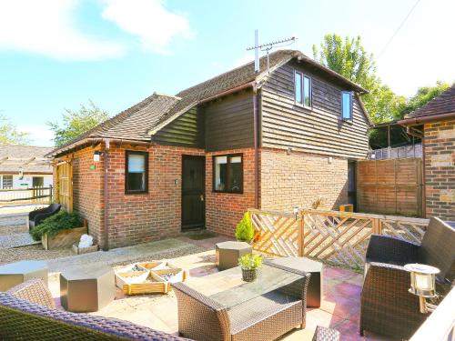 ein Backsteinhaus mit einer Terrasse mit Tisch und Stühlen in der Unterkunft Walnut Walk in Uckfield