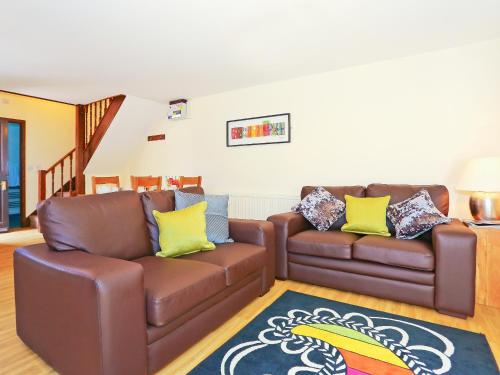 ein Wohnzimmer mit zwei Ledersofas und einem Teppich in der Unterkunft Walnut Walk in Uckfield