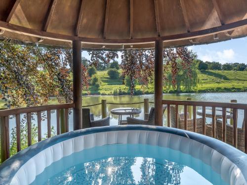 a pool on a deck with a view of the water at Croxton Lodge & Curlews Nest in Croxton Kerrial