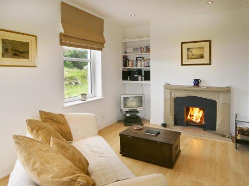 a living room with a couch and a fireplace at Tigh Beg in Lerags