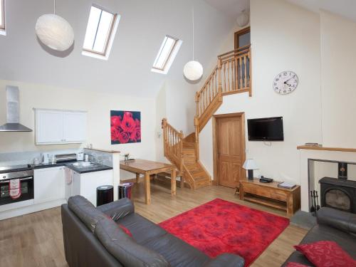 a living room with a couch and a kitchen at Rose Cottage - Ukc6257 in Linlithgow