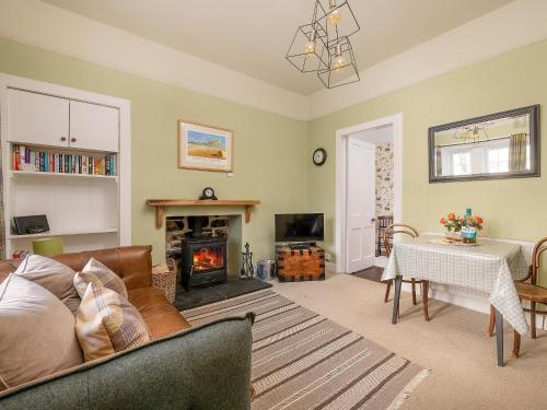 a living room with a couch and a fireplace at The Lodge in Duffus