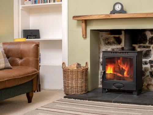 a living room with a fireplace with a stove at The Lodge in Duffus