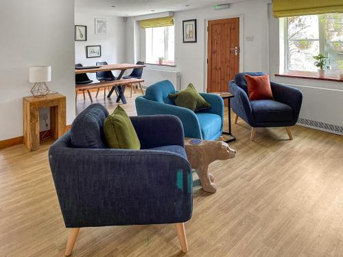 a living room with two blue couches and a dog statue at Nutley Farmhouse in Uckfield