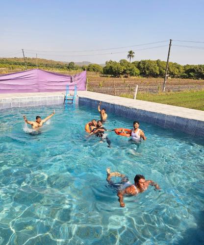 a group of people swimming in a swimming pool at Girvana Resorts in Sāsan Gīr
