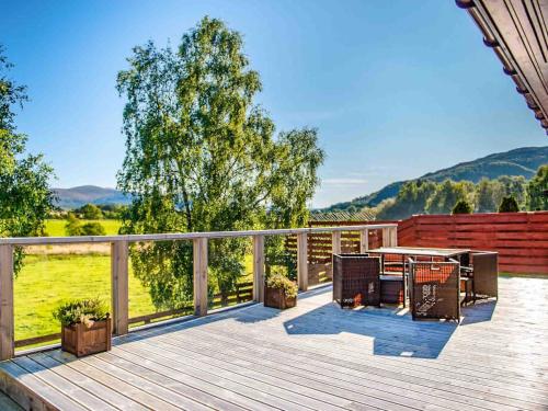 a deck with a table and chairs on it at Mountain View-Ukc5060 in Aviemore
