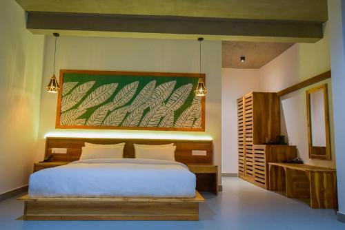 a bedroom with a bed and a large painting on the wall at Mistara Ella in Ella