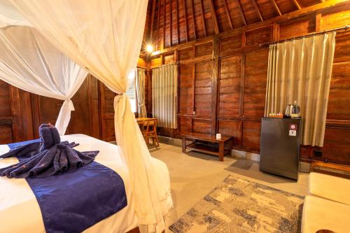 a bedroom with a bed with a canopy at Damar Sanjaya Uttama in Amed