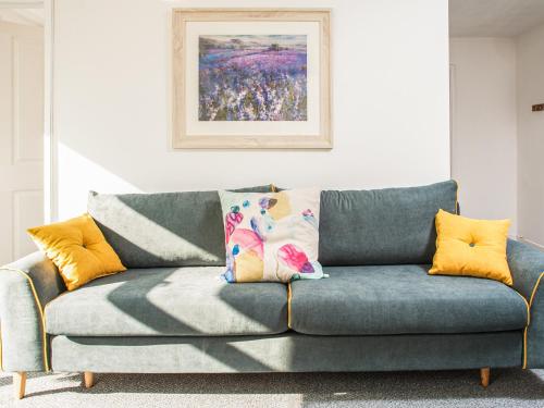 a blue couch in a living room with a painting at Newport House Lower in Newport