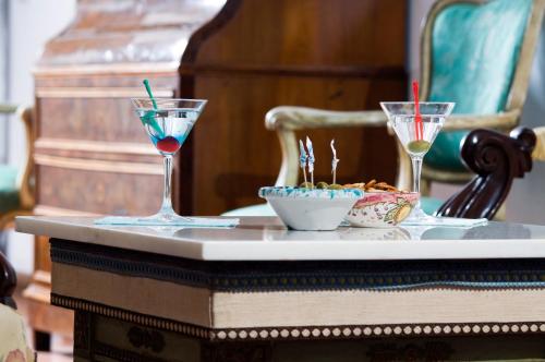 a table with two glasses and a bowl of food on it at Hotel La Villarosa Terme in Ischia