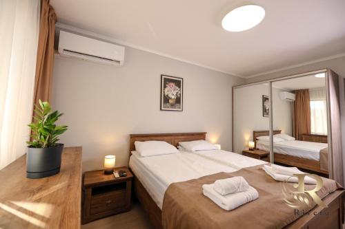 a bedroom with two beds and a large mirror at Apartments Rivera in Dobrich