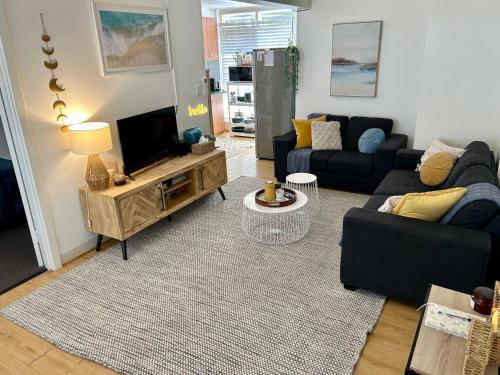 a living room with a couch and a tv at Sunshine Five in Salisbury