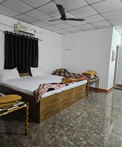 a bedroom with two beds and a ceiling at Girvana Resorts in Sāsan Gīr