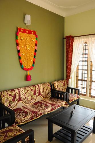 a living room with a couch and a table at SHANKARAM Homestay in Kodanad