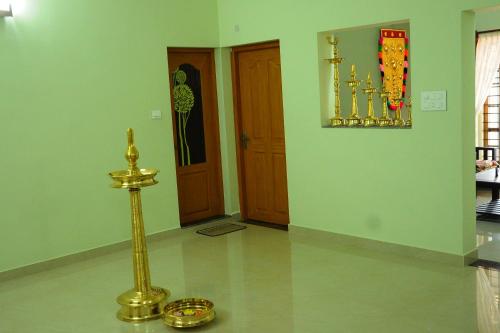 a room with a gold object on the floor and a door at SHANKARAM Homestay in Kodanad
