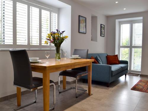a living room with a table with chairs and a couch at Lloch Lo in Cilybebyll