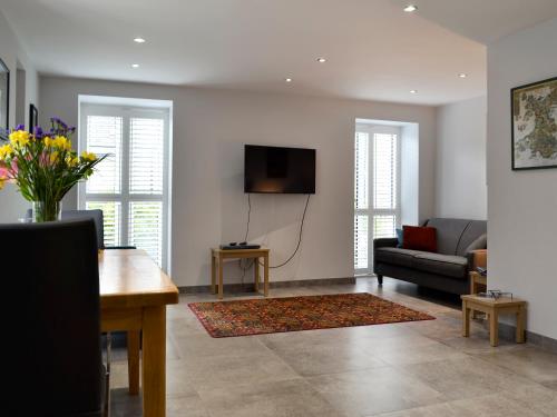 a living room with a couch and a tv at Lloch Lo in Cilybebyll