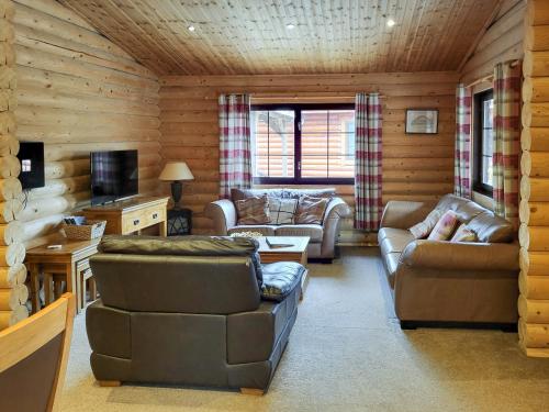 a living room with couches and chairs in a cabin at Tyne Log Cabin - Uk3480 in West Thirston