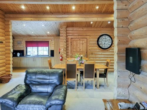 a dining room with a table and a clock on a wall at Tyne Log Cabin - Uk3480 in West Thirston