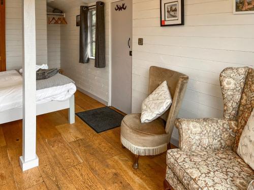 a living room with a chair and a bed at Castle Lodge - Uk50987 in Sheriff Hutton