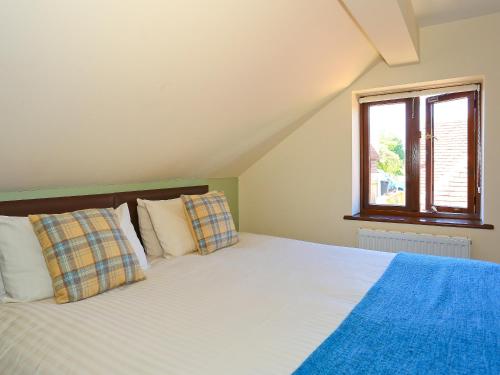 a bedroom with a bed and a window at Chestnut Cottage in Uckfield