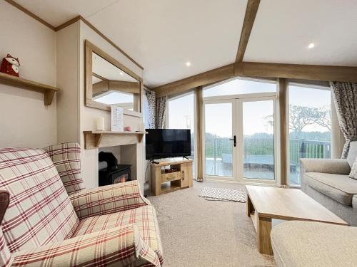a living room with a couch and a tv at Glenmoore 23 in St. Andrews
