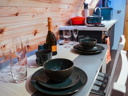 a table with a bottle of wine and plates and glasses at Rowan-Uk7588 in Stewarton