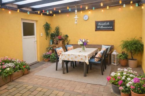 eine Terrasse mit Tisch, Stühlen und Blumen in der Unterkunft Pension Bertuch in Peitz