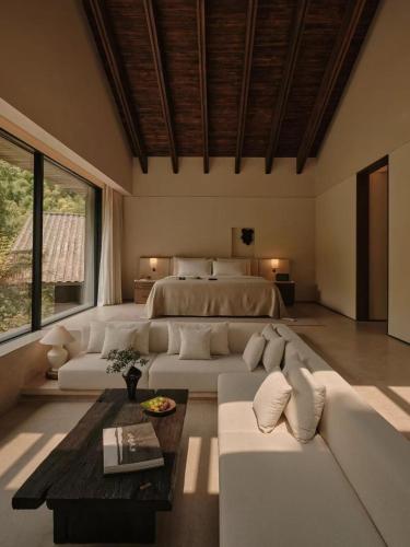 a bedroom with a bed and a couch and a table at ZOLAND Resort Hotel ·Emei Mountain in Emeishan City