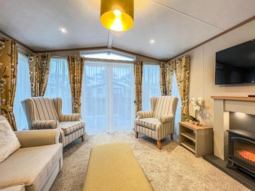 a living room with two chairs and a fireplace at Abington 14 in St. Andrews