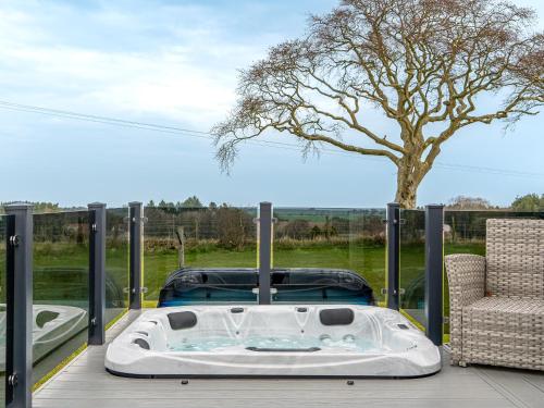 a hot tub sitting on a deck with a tree at Lyndale 18 in St. Andrews
