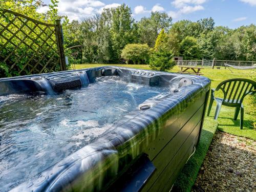 a large plunge pool in a yard with a chair at Honeysuckle - Uk35244 in Llanfyrnach