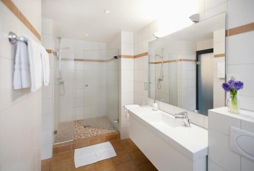 a white bathroom with a sink and a mirror at Vinotel Dirmstein in Dirmstein